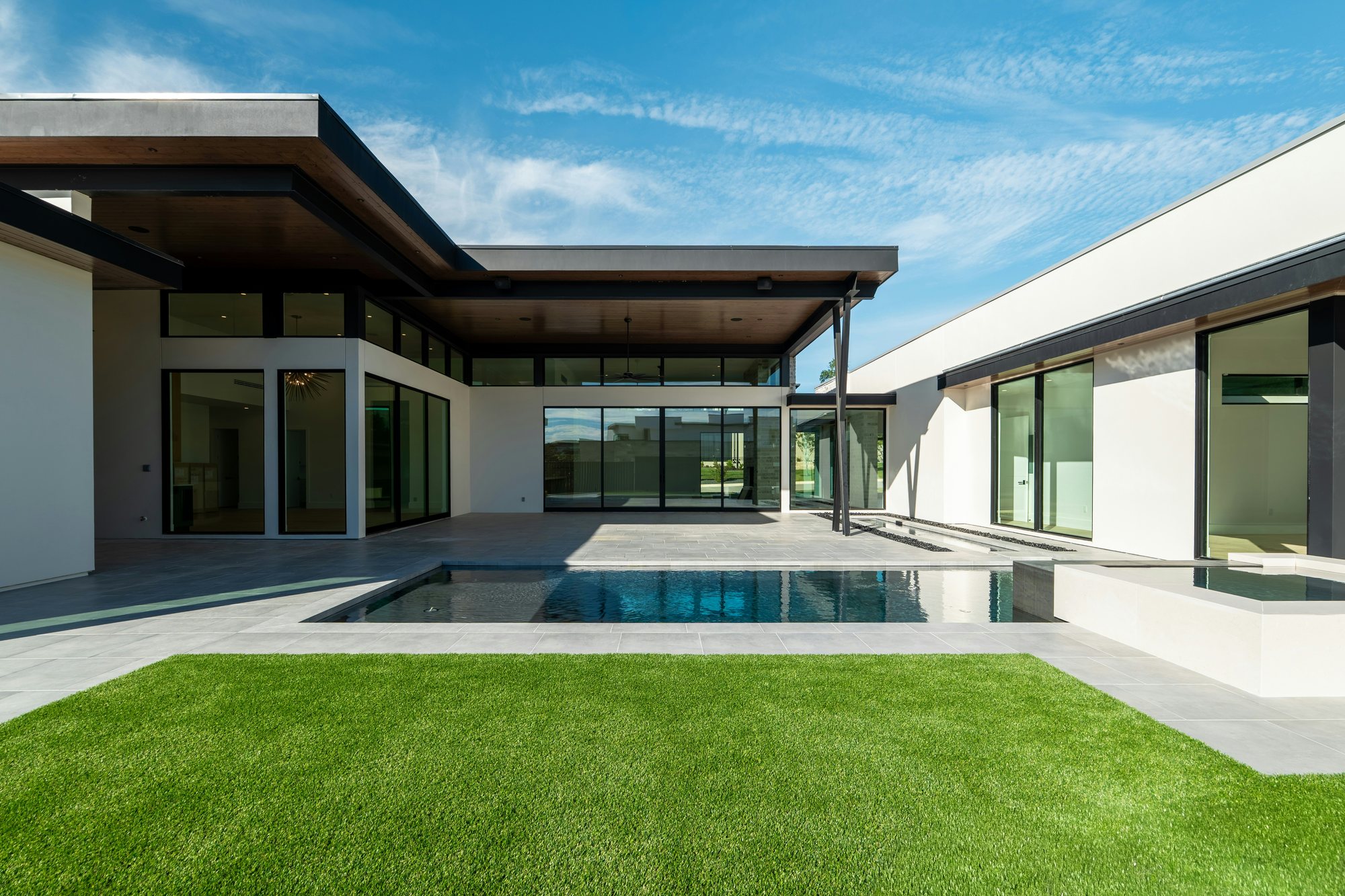 Private courtyard at Common Ground with a pool, lawn and modern single level homes